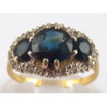 An 18 carat gold sapphire and diamond ring, largest sapphire approx 7.3mm diameter, size O, 4.3 gms.