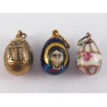 Three Russian miniature eggs, being two enamelled with maker's mark, one also with 84 silver mark,