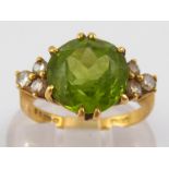 An 18 carat gold peridot and diamond ring, peridot approx 11mm diameter, ring size G, 5.5 gms.