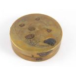 A Japanese Shibayama brass circular box with white metal bird and flower appliques. 9cm. diameter.