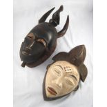 Two tribal masks, one from the Pounou tribe, Gabon, the other the Yaoure tribe, Ivory coast.