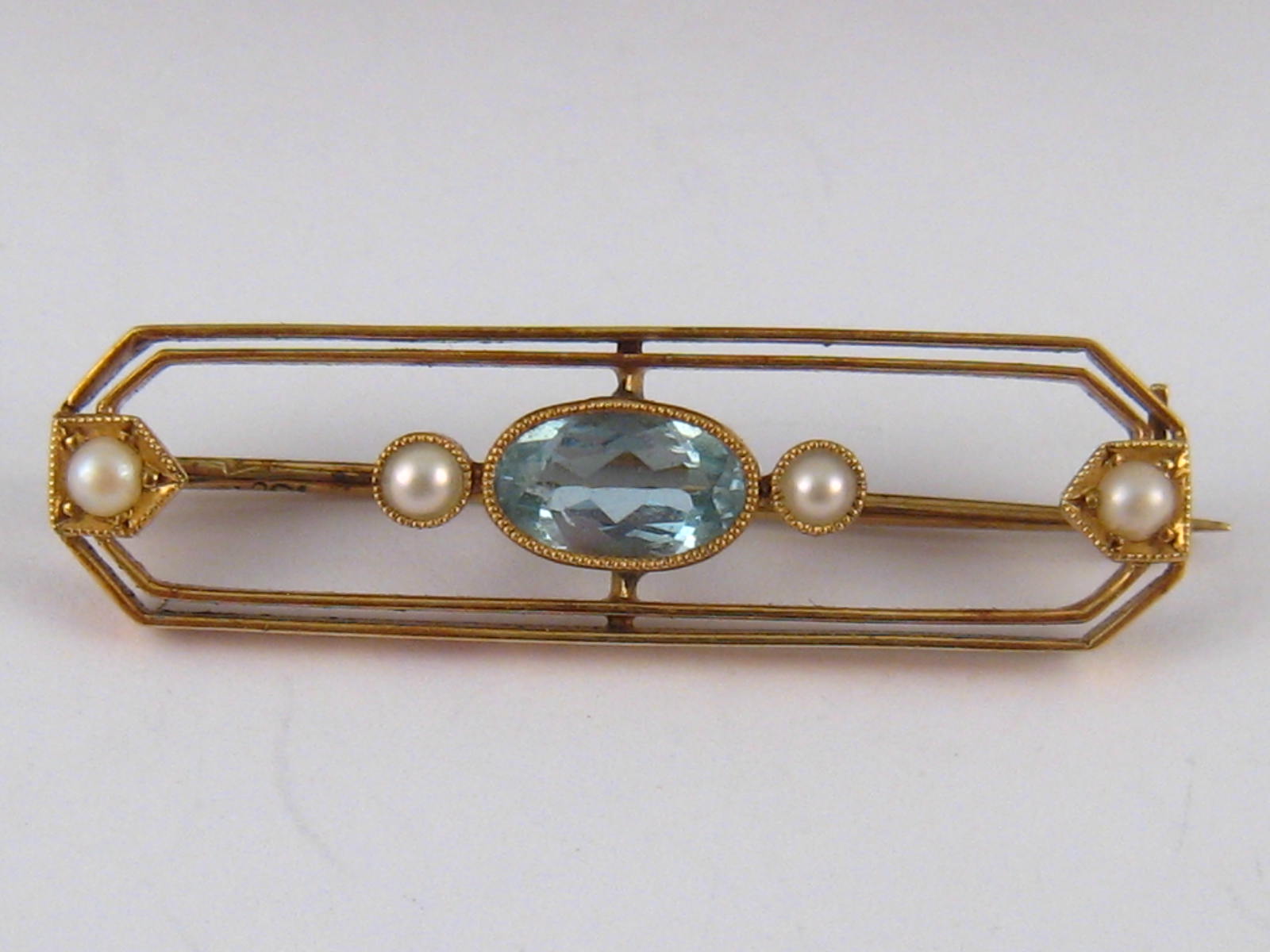 A 15 carat gold aquamarine and seed pearl bar brooch, stone approx 7.5 x 4.5mm, 3.5cm long, 3.