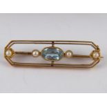 A 15 carat gold aquamarine and seed pearl bar brooch, stone approx 7.5 x 4.5mm, 3.5cm long, 3.