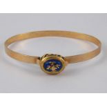 A yellow metal (tests 9 carat gold) bangle with an enamelled clasp, approx 5.5cm internal width, 8.