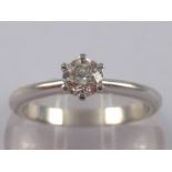 A white metal (tests 18 carat gold) round brilliant cut diamond solitaire ring,