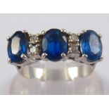 101 A white metal (tests 18 carat gold) sapphire and diamond ring, sapphires approx 7 x 5mm,