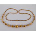 A yellow metal (tests 18 carat gold) necklace, designed as graduated beads on a Chinese style chain,