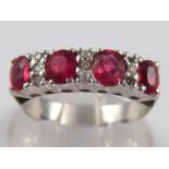 A white metal (tests 18 carat gold) ruby and diamond ring, larger rubies approx 5x4mm, size P, 2.