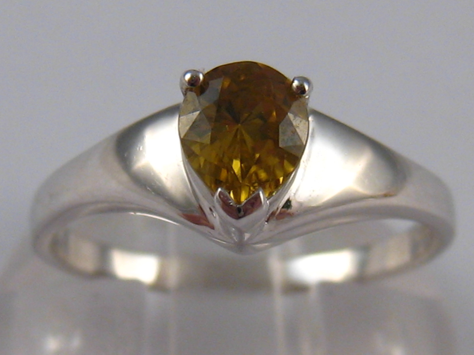 A white metal (tests 9 carat gold) yellow zircon ring, size N, 2.3gms.