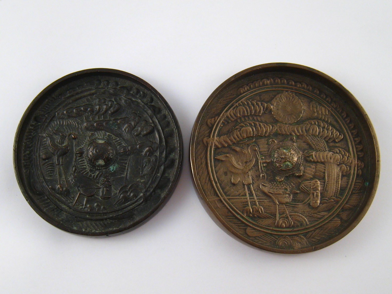 Two oriental bronze mirrors, 10cm. and 11cm. diameter.