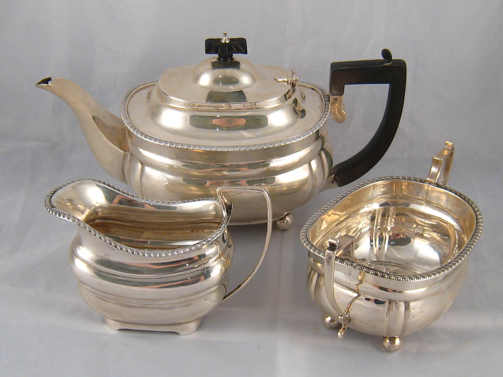 A three piece silver teaset, barge shaped with gadrooned rim,