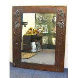 A copper framed Art Nouveau mirror embossed with stylised leaf and pomegranate forms after Charles