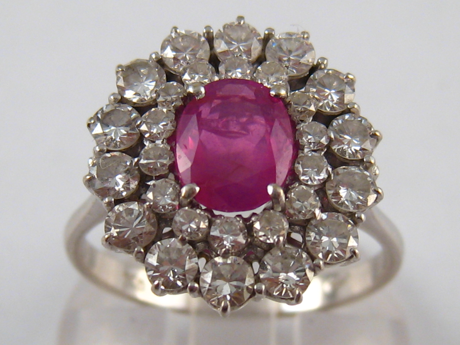 A white metal (tests 18 carat gold) diamond and ruby ring, the ruby measuring approx. 7.