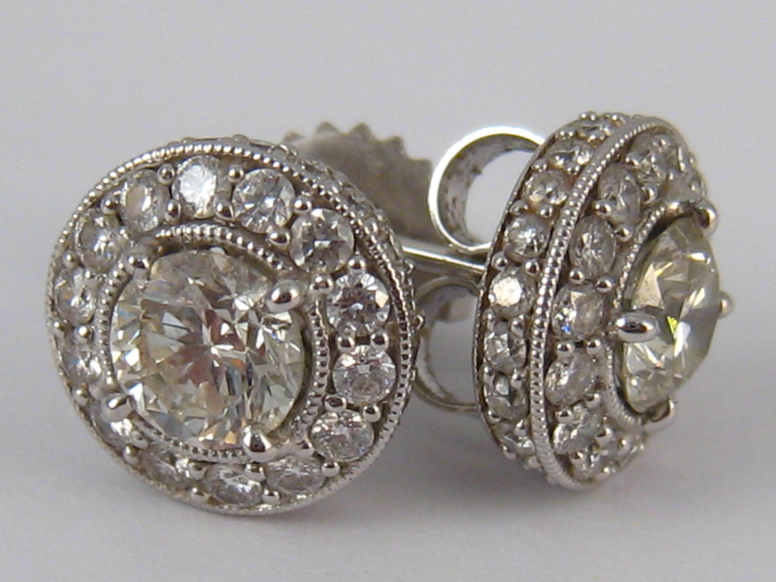 A pair of white metal (tests 14 carat gold) diamond earrings,