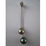 A white metal (tests 18 carat gold) diamond and grey cultured pearl negligee pendant,