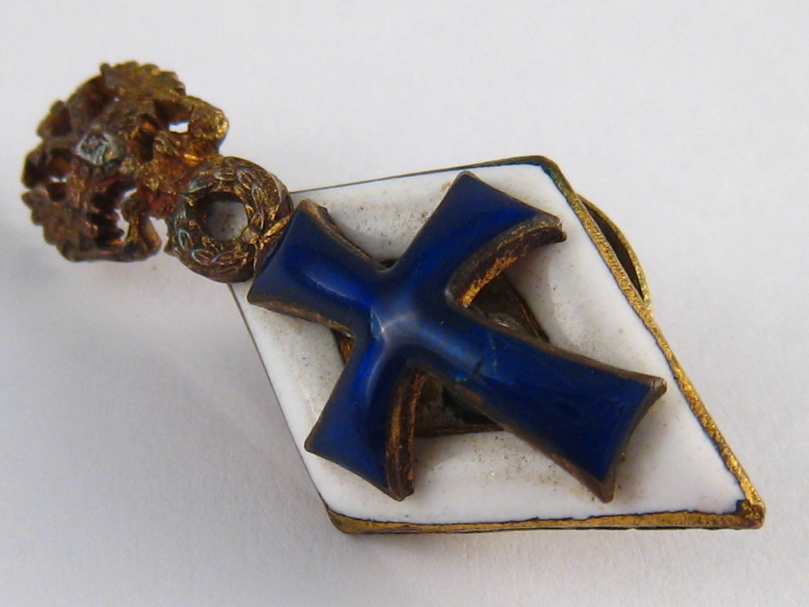 A Russian silver lady's university lapel badge bearing an enamel cobalt blue cross on a white