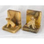 A pair of onyx bookends with seated 7.5cm. high cold painted cast dogs.