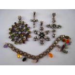 A mixed lot comprising four white metal (tests silver) pendants set with various stones,