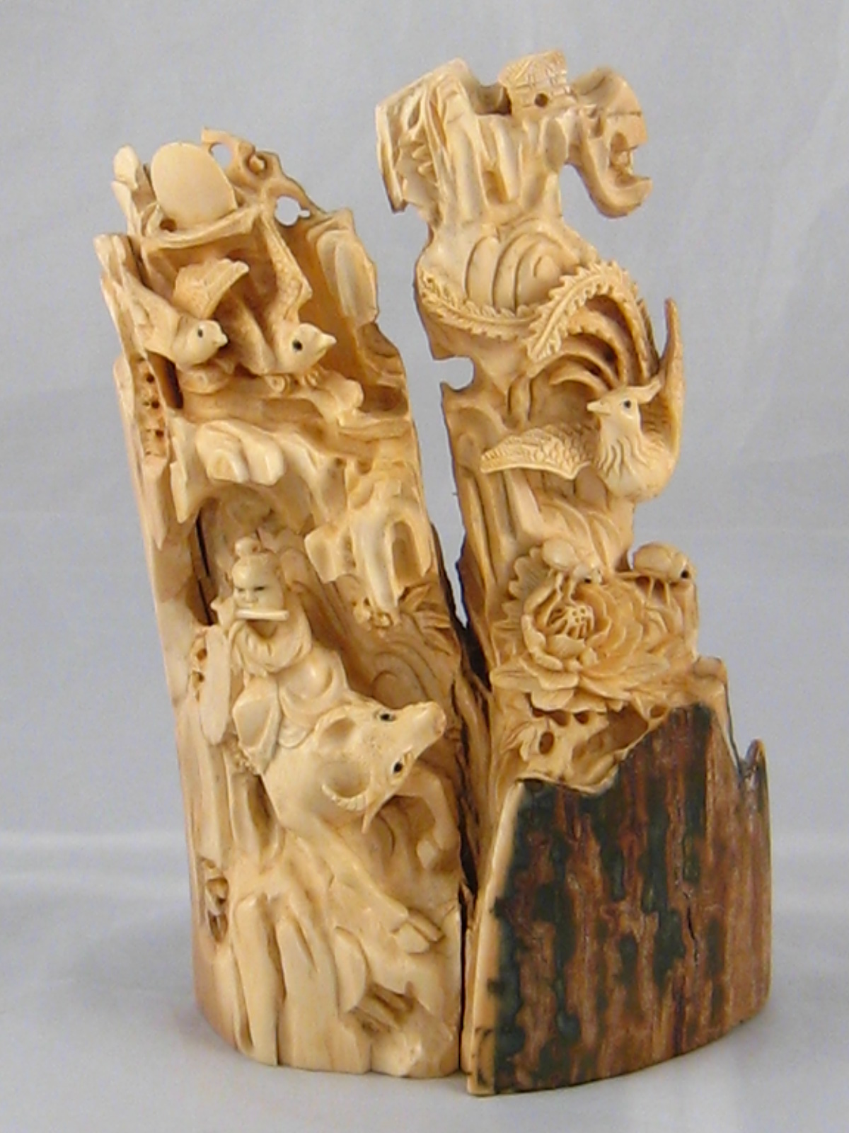 An ivory part tusk carved as figures , animals, insects and birds , all with inset eyes.