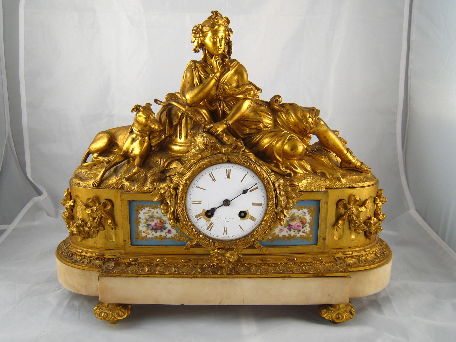 A large ormolu clock on marble base representing Diana the huntress and her hound resting,