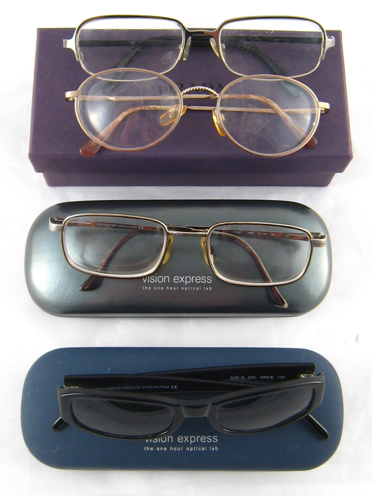 A pair of Armani sunglasses and three pairs of prescription spectacles.