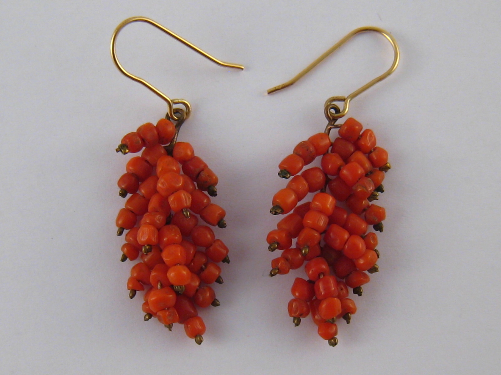 A pair of coral drop earrings with yellow metal (tests 18 carat gold) wire fittings, approx 4.