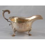 A heavy silver sauce boat with leaf capped flying C handle on pad feet, Carrington and Sons,