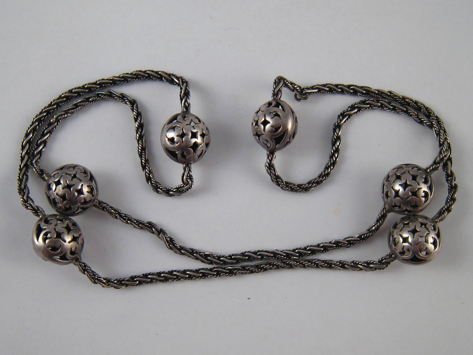 A white metal (tests silver) necklace. Beads approx. 15mm wide, necklace approx. 66cm long, 32.5gms.