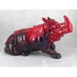 A Doulton ceramic rhinoceros with mottled red flambe glaze,