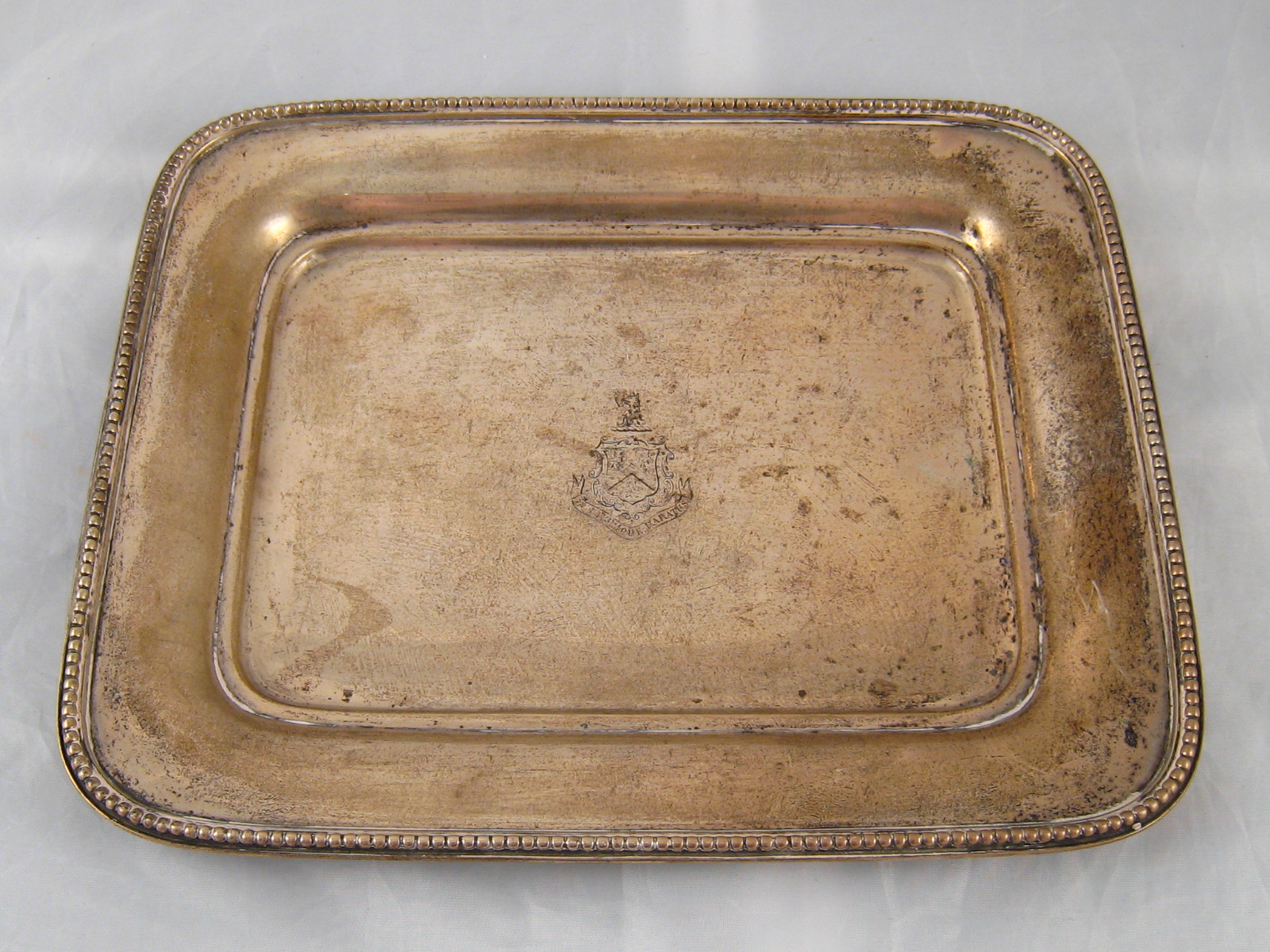 A small rectangular silver tray with curved corners , beaded rim and central armorial. Dutch .