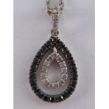 A white metal (tests 9 carat gold) black and white diamond pendant necklace, chain approx 42cm long,