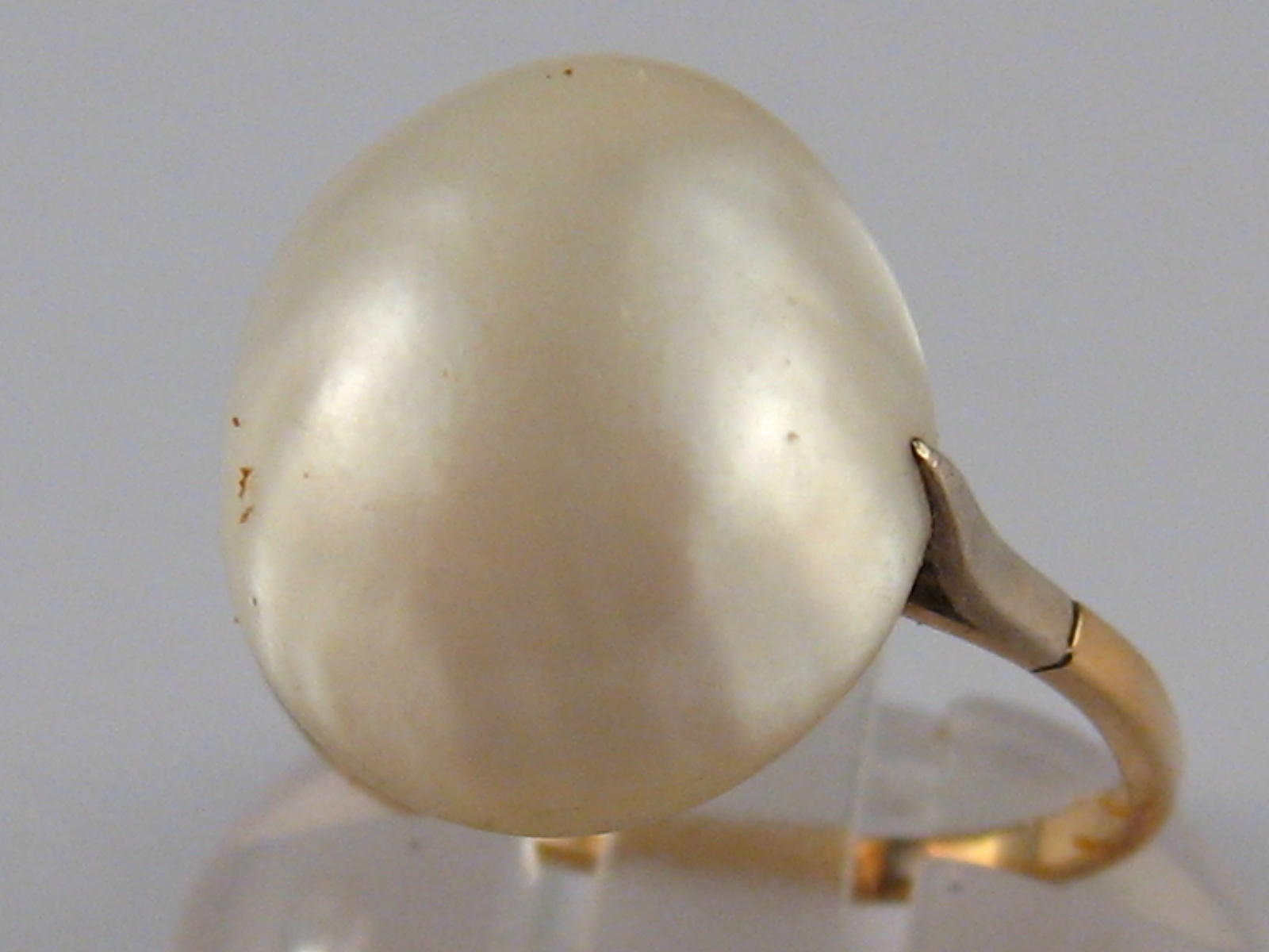 A yellow metal (tests 9 carat gold) untested baroque pearl ring, pearl approx 14mm long,