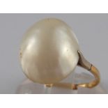 A yellow metal (tests 9 carat gold) untested baroque pearl ring, pearl approx 14mm long,