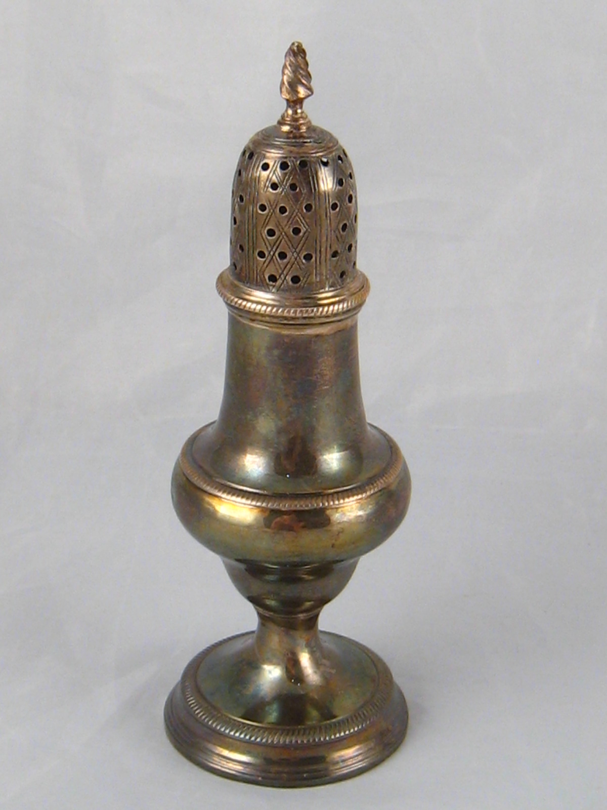 A Georgian silver pepper, Thomas Shepherd, London 1783. Ht. 15cm., wt.88gm.