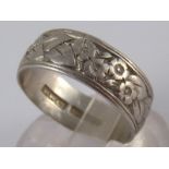 A platinum band ring with chased and engraved floral decoration, approx 6mm wide, size M, 5.5 gms.