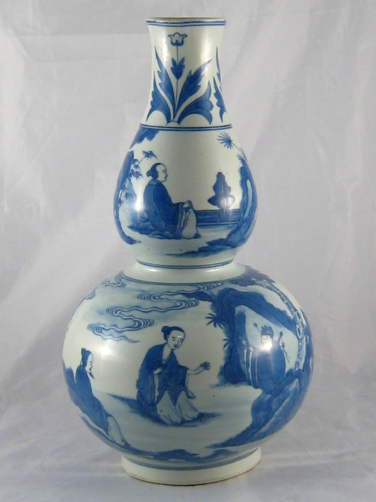 A 20th century double gourd shaped Chinese vase with landscape in blue and white. Ht.39cm. Repaired.