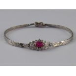 A white metal (tests 14 carat gold) ruby and diamond bracelet, the ruby measuring approx 6 x 4mm,