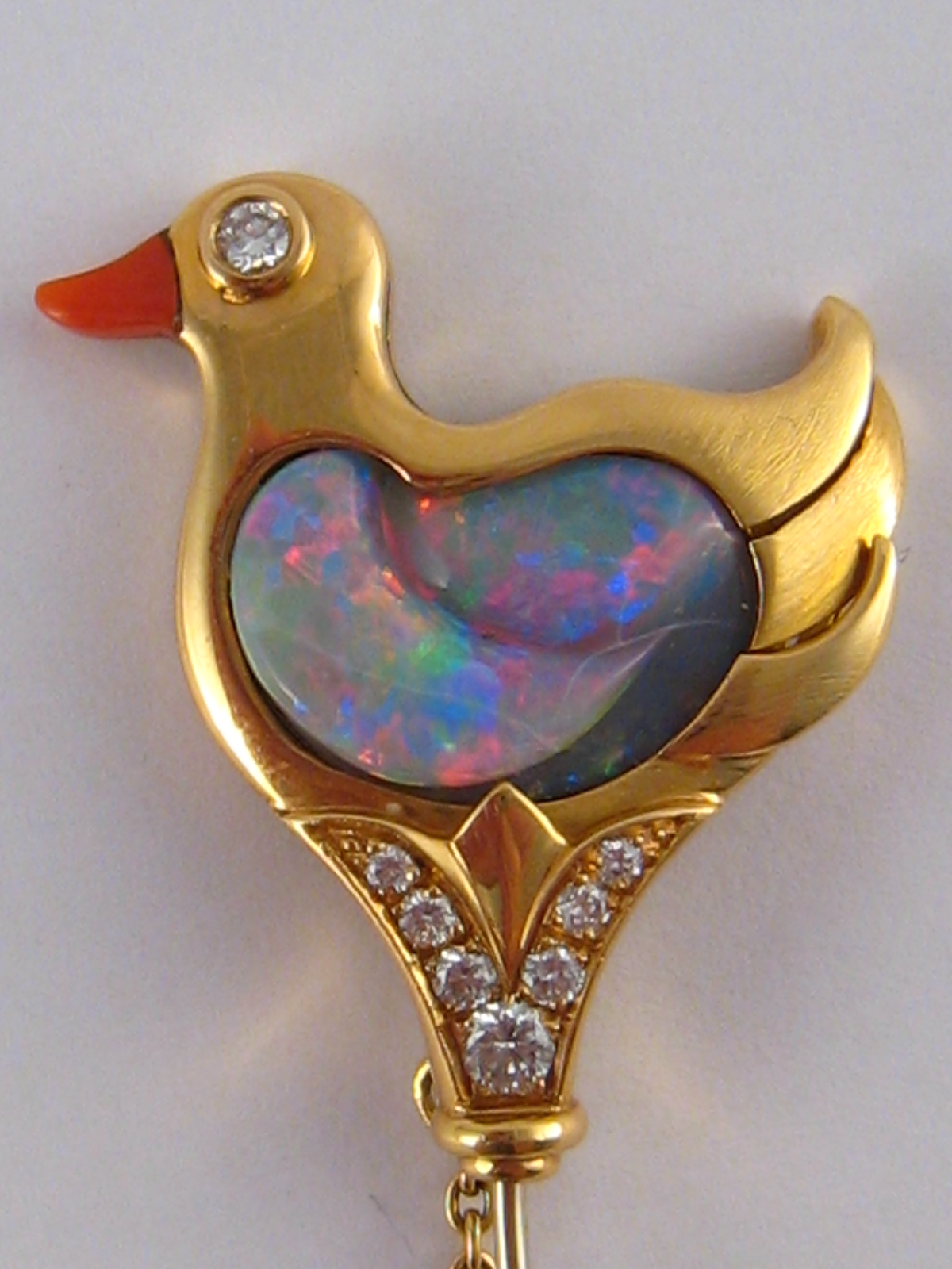 A fine 18 carat gold brooch designed as a duck with an opal body and coral beak,