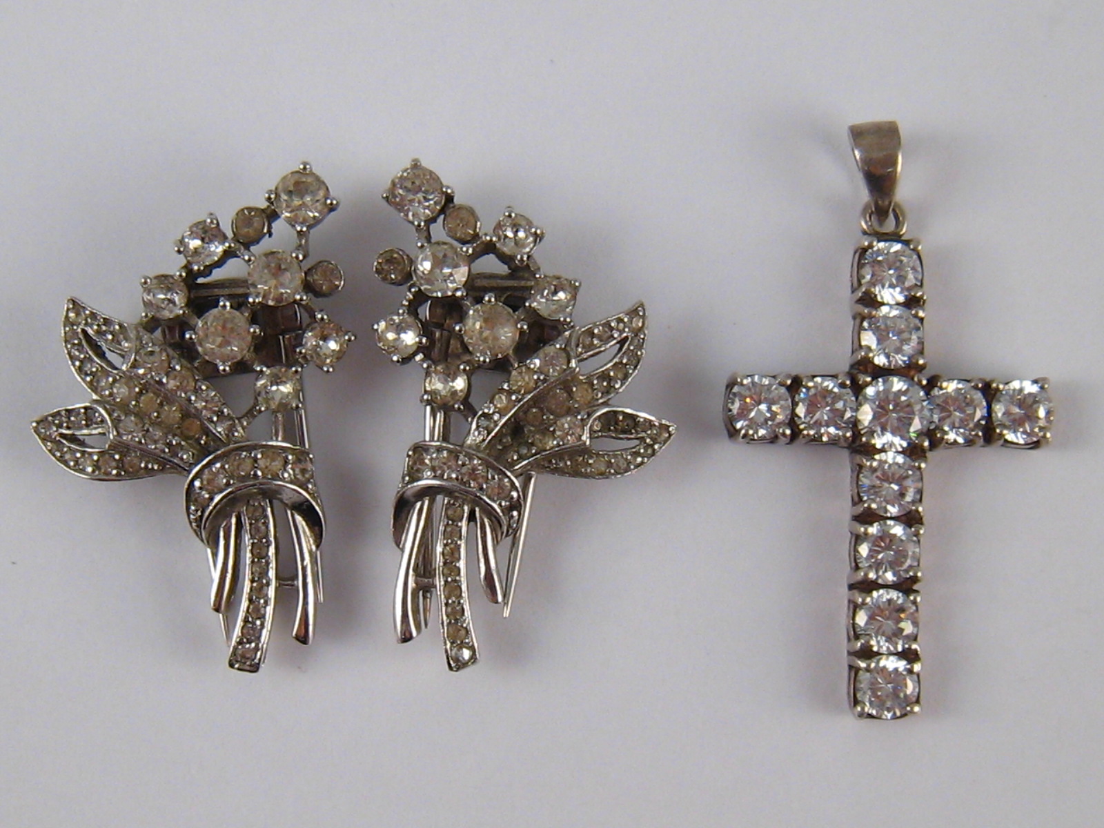 A mixed lot comprising a white metal (tests silver) diamante cross,