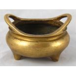 A Chinese bronze censer on three stub feet, inset calligraphy to underside. 11cm. across.