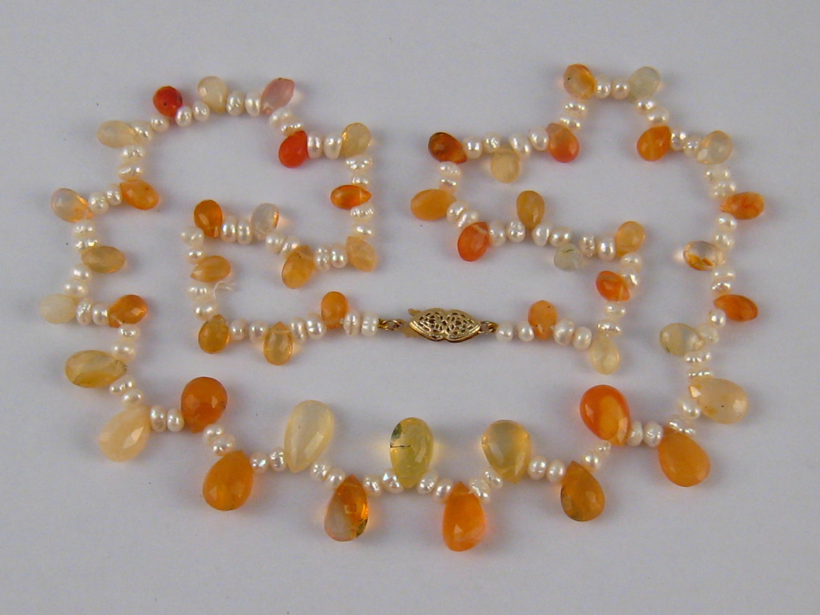 A cultured pearl, fire opal and citrine necklace with a yellow metal (tests 14 carat gold) clasp,