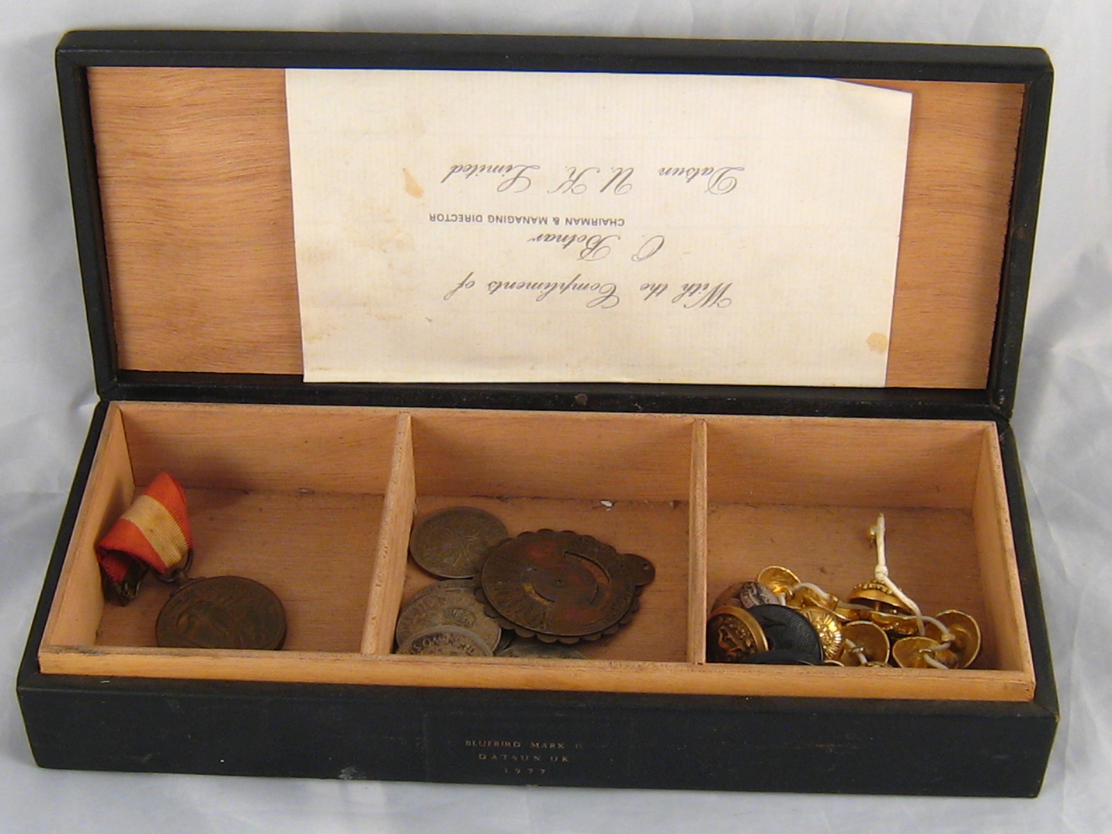 A box contaning a mixed lot of military brass buttons, pre 1947 British "silver " coinage,