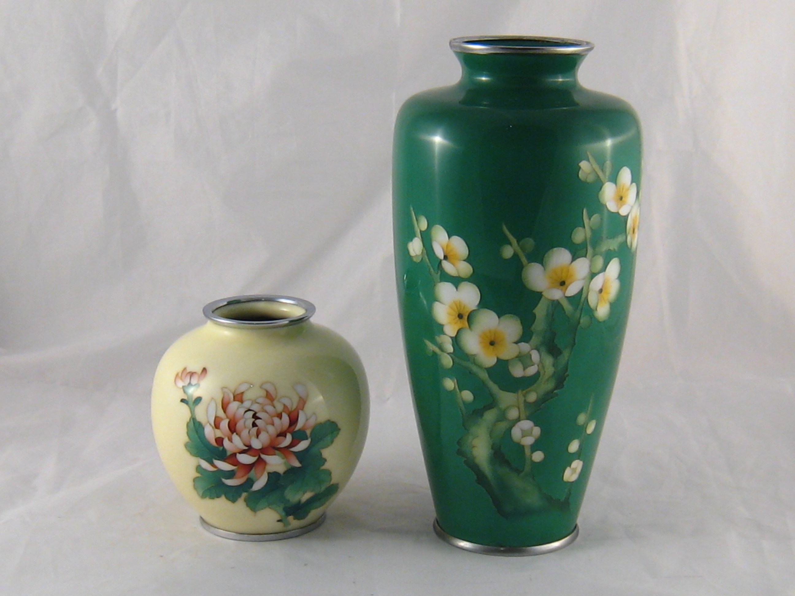 A 1920s Japanese cloisonne vase with chrysanthemum flower and bud inset in the cream body, ht.12cm.