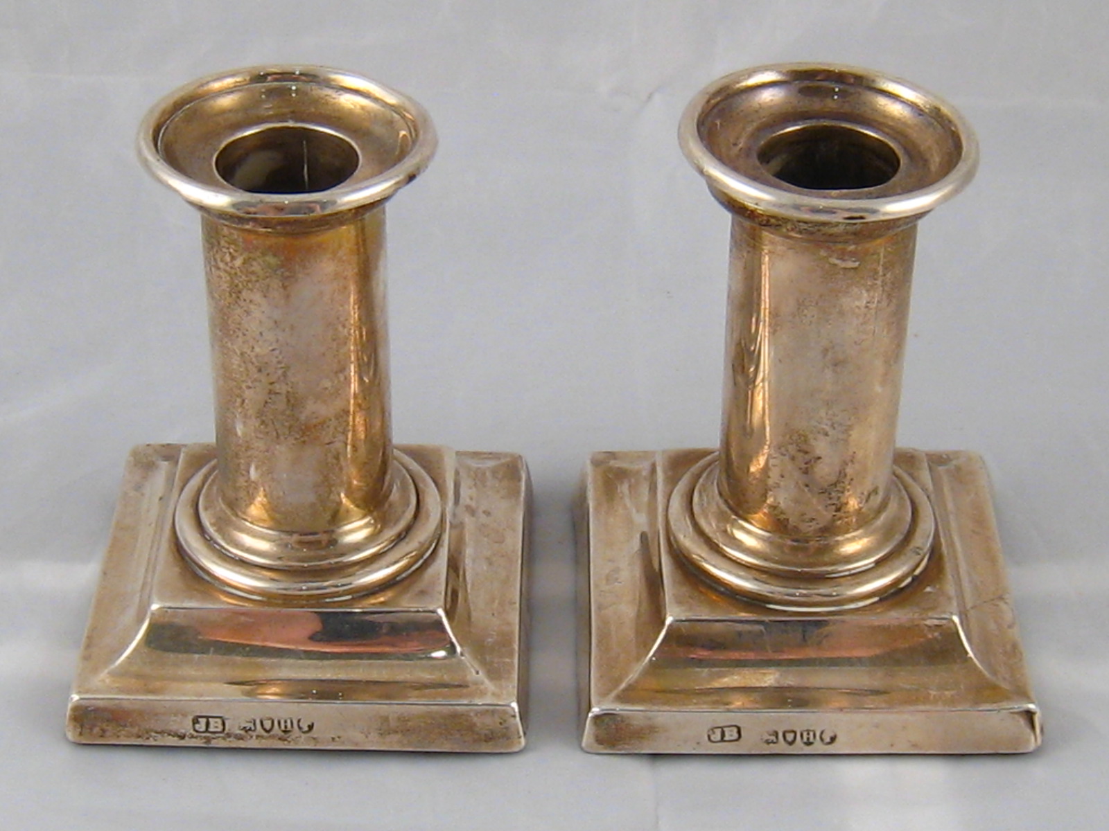 A pair of Victorian silver short column candlesticks on square bases, London 1883. Ht.9.5cm.