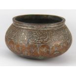 An antique Syrian copper bowl with thickened rim and traces of silvering,