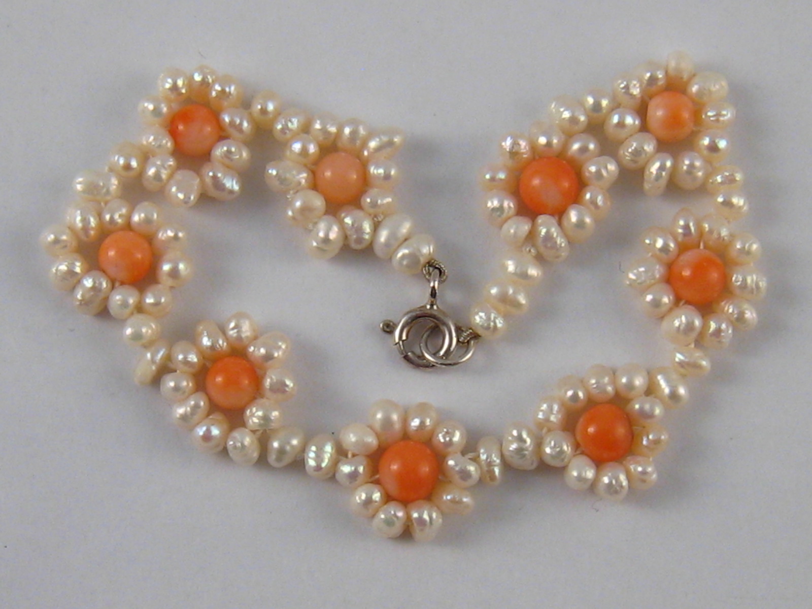 A cultured pearl and coral bracelet. Length approx. 9cm, width approx.12mm.