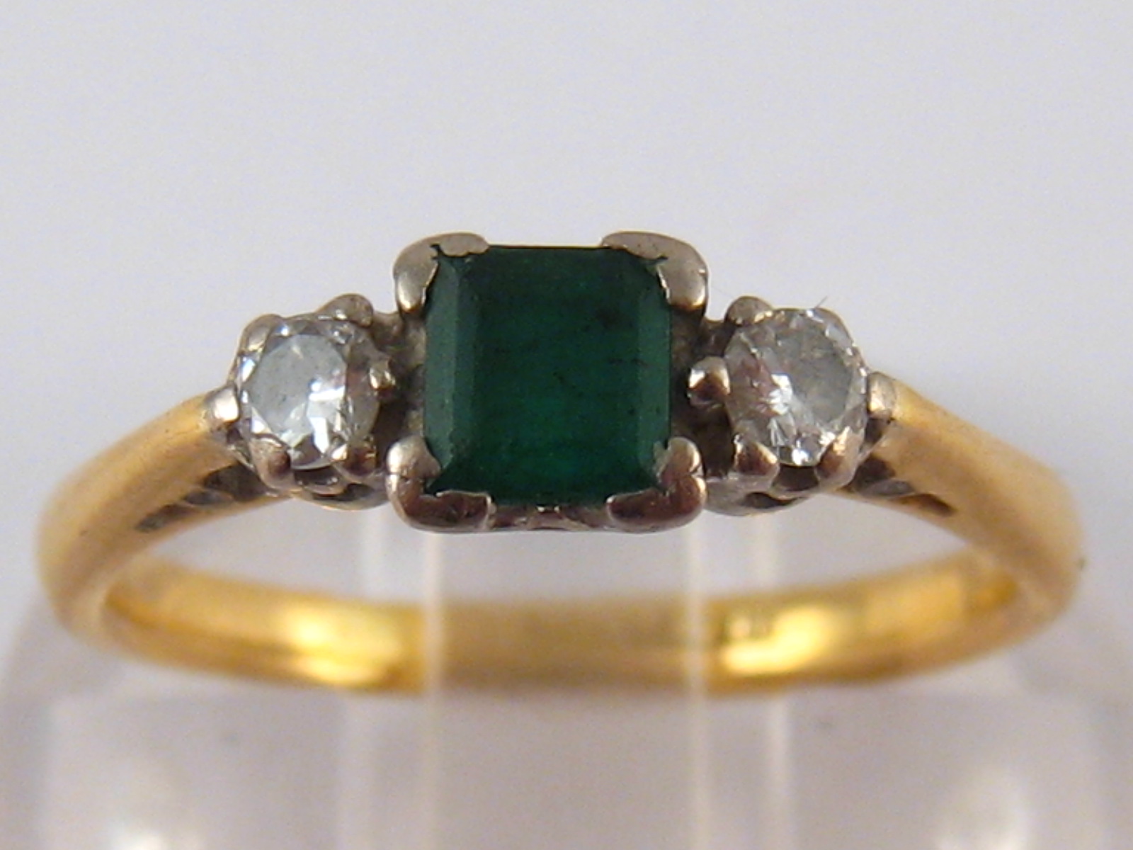 A yellow metal (tests 18 carat gold) emerald and diamond ring, emerald approx 4x4mm,