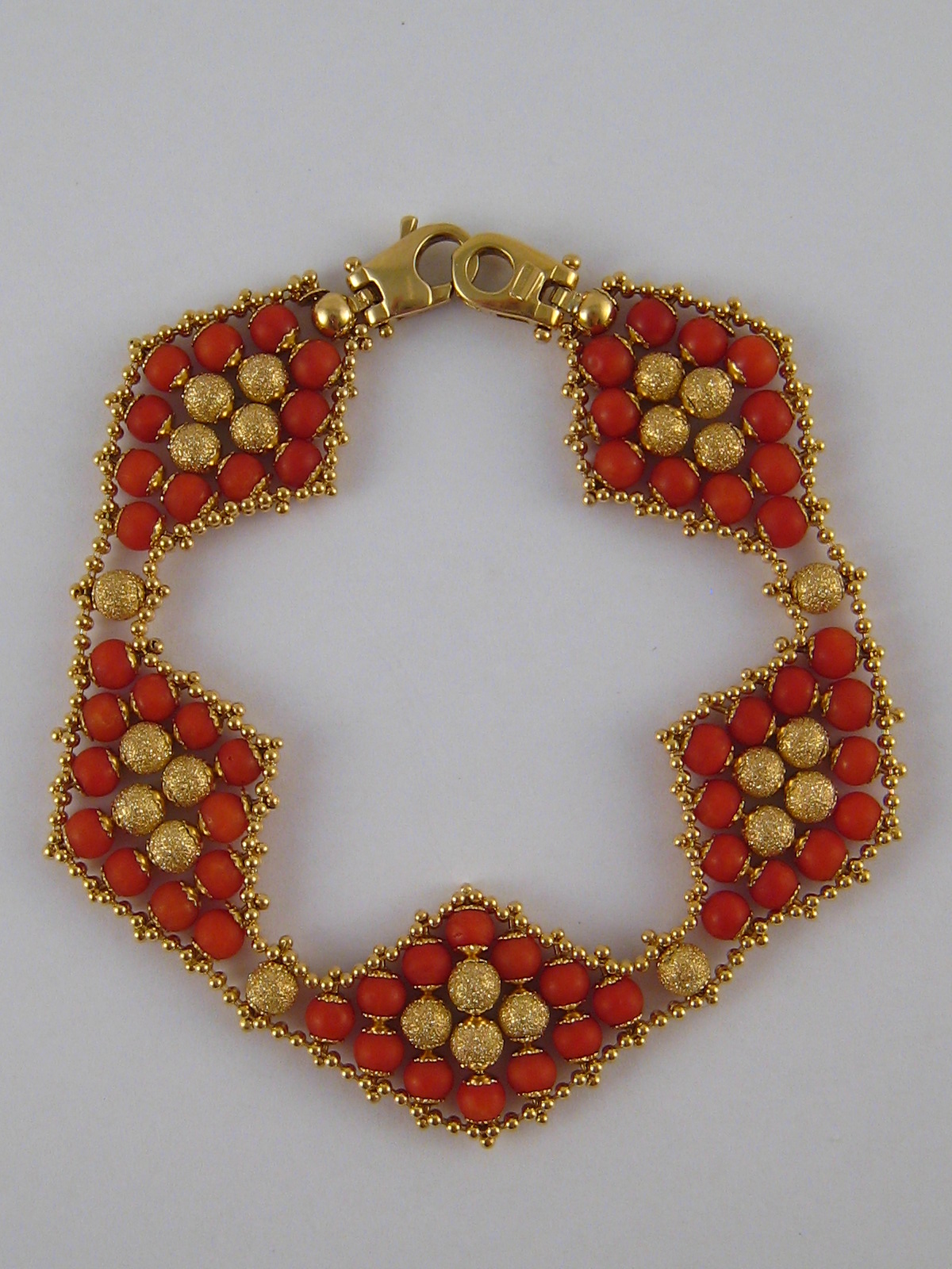 A yellow metal (tests 18 carat gold) coral bracelet, approx 19cm long, 2cm wide, 20.7 gms.