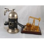 A gold plated battery operated model "nodding donkey" oil well, 19x16x17cm. high.