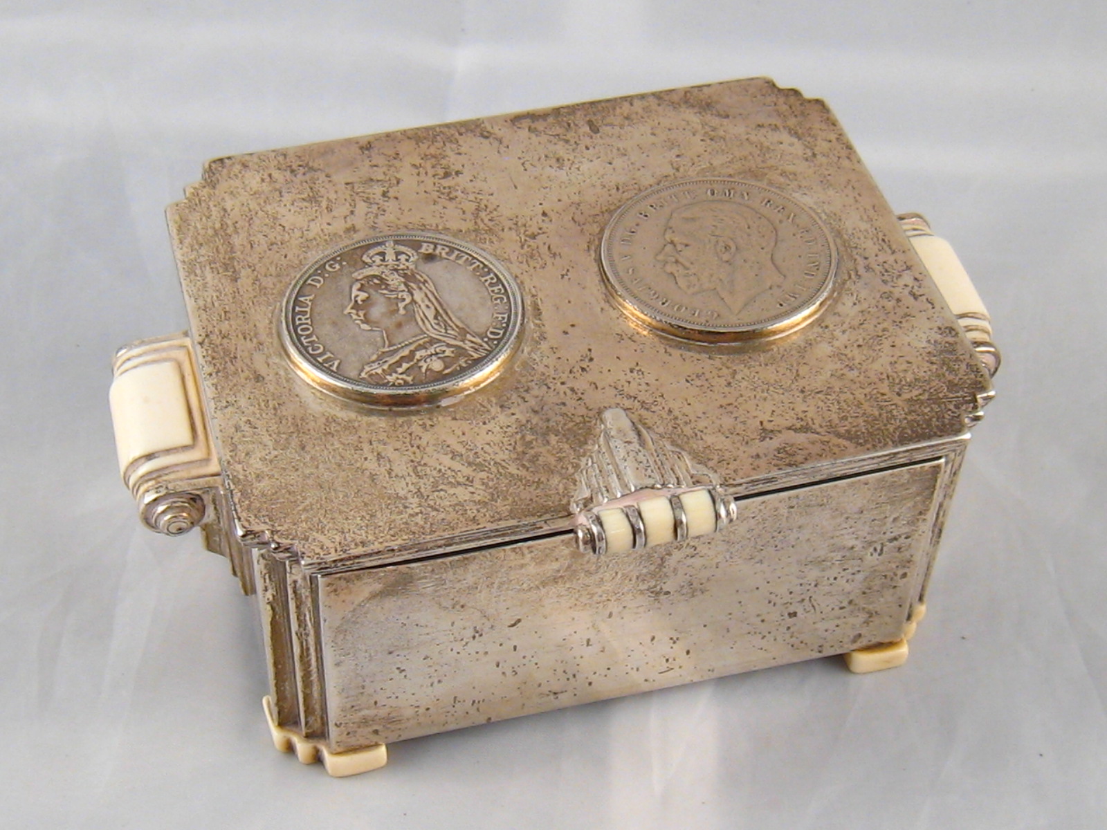 An Art Deco silver casket with ivory handles and feet,